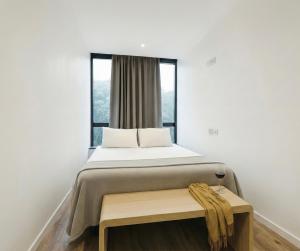 a bedroom with a bed with a table and a window at Capsula Hotel Sao Paulo - Paulista in São Paulo