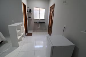 een witte badkamer met een wastafel en een spiegel bij Casa-Quarto Parnaíba in Parnaíba