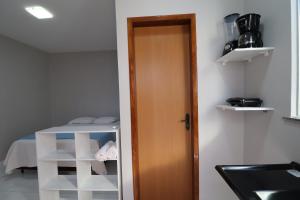 een kamer met een keuken met een deur en een bed bij Casa-Quarto Parnaíba in Parnaíba