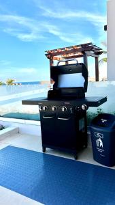 a grill sitting on a patio next to a beach at Sifah Seascape Villa with Private Pool in As Sīfah