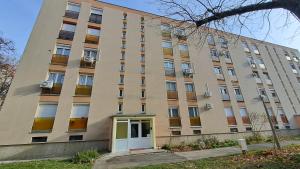 a large building with a door in front of it at Tímea Apartman Pécs in Pécs