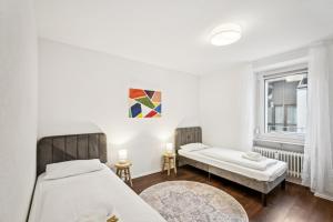 Un dormitorio con dos camas y una ventana. en Home Wutach Blue - Business Apartment near Swiss Border, en Lauchringen