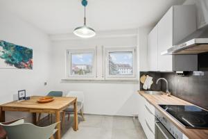 Una cocina con una mesa de madera y un comedor. en Home Wutach Blue - Business Apartment near Swiss Border, en Lauchringen 7 fotos más