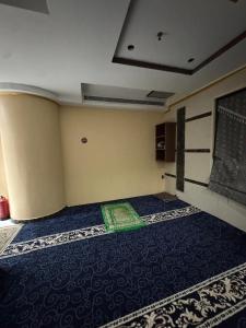 ein leeres Zimmer mit einer grünen Matte auf dem Boden in der Unterkunft Jazirat Al Balad in Muzdalifah