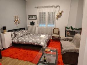 a bedroom with a bed and a couch and a chair at Trikala Groundhouse in Rizareión