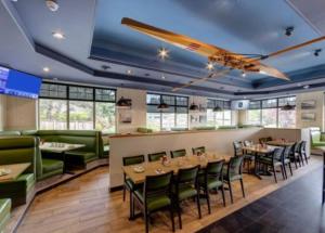 a restaurant with tables and chairs and a bar at Holiday Inn Victoria - Elk Lake by IHG in Victoria