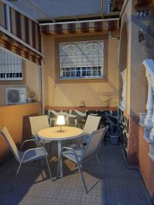 a patio with a table and chairs and a window at PepeHills in Gran Alacant