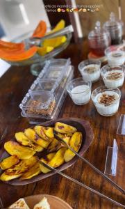 a table with a plate of bananas and other ingredients at Pousada Lumawê Caraíva in Porto Seguro