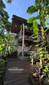a wooden deck with a building with a roof at Pousada Lumawê Caraíva in Porto Seguro +22 photos