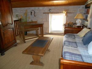 MARAIS POITEVIN bord rivière pêche ,barque, vélos, wifi, linge, cheminée, cuisine, terrain de boules في La Taillée: غرفة نوم بسرير وطاولة وبيانو