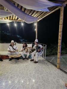 three people sitting on a bench under a tent at Tayrona Colors Hostel in Taganga +73 photos