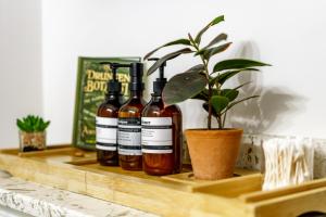 quatro garrafas de vinho em uma prateleira de madeira com uma planta em Jungle House Luxury Homes - Columbus Downtown Short North - Walk to Convention Center & Nationwide Arena - Sleeps up to 10 - Free Parking - Over 5,800 Five Stars em Columbus