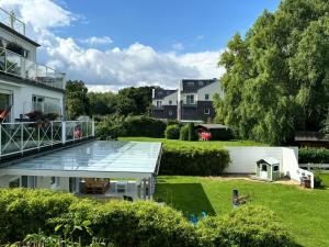 a house with a glass roof and a yard at Family Beach Appartement Laboe in Laboe