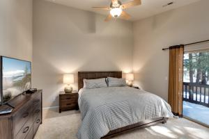 ein Schlafzimmer mit einem Bett, einem Fernseher und einem Fenster in der Unterkunft Meadow Chalet townhouse in South Lake Tahoe