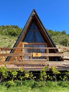 uma cabana com telhado de palha e deck de madeira em Chalé romântico com hidro, lareira e churrasqueira na Serra em Serra Negra