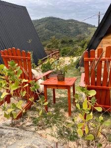 duas cadeiras e uma mesa num quintal em Chalé romântico com hidro, lareira e churrasqueira na Serra em Serra Negra