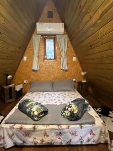 Giường trong phòng chung tại Chalé romântico com hidro, lareira e churrasqueira na Serra