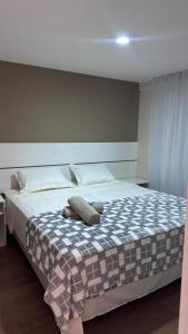 カンポ・グランデにあるFlat moderno em Campo Grande com fácil acessoのベッドルーム1室(大型ベッド1台、チェック入りの毛布付)