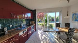 a kitchen with a wooden table and a dining room at Ferienhaus Windland - mit Garten, Kamin und Sauna in Dranske