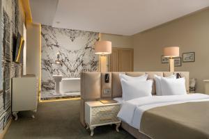 Una habitación de hotel con una cama grande y un baño. en Domeniile Martinutzi - Conac Rhédey, en Vintu De Jos 19 fotos más