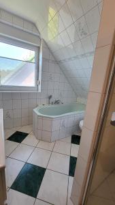 bagno con vasca verde e finestra di Ferienhaus Windland a Hof Dranske Altre 18 foto