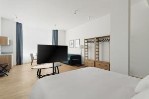 a hotel room with a bed and a flat screen tv at Whitlock16 - Luxe Aparthotel Montgomery Square Brussels in Brussels
