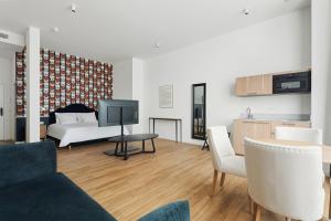 a living room with a couch and a tv and a table at Whitlock16 - Luxe Aparthotel Montgomery Square Brussels in Brussels