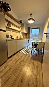 a kitchen with a table and a dining room at VerdeViu Apartments 1 Prima Residence Universitatii in Oradea