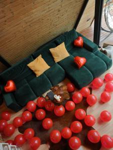 a green couch with red tomatoes on the floor at A-Wine Villas in Novaci-Străini