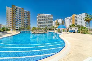 a large swimming pool with buildings in the background at Hotel apartment studio in Dherinia