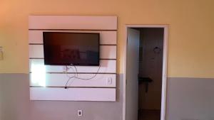 a flat screen tv on a wall in a room at JR POUSADA in Morro do Chapéu