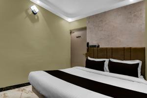 a bedroom with a large bed with black and white pillows at Hotel O KOLKATA SEVEN INN LLP in Salkhia