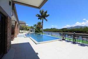 a swimming pool on a patio with a view of the water at Naisoso Island Villa - Fiji in Nadi
