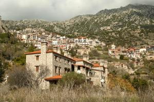 an old building in front of a town on a mountain at Elysian Villa by Ski Alure in Arachova