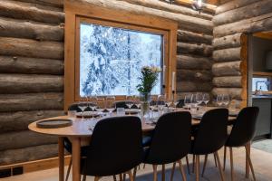 a dining room with a table and chairs and a window at Kelokurki - The Luxury Lodge Where Serenity Meets the Northern Lights in Levi