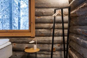 a room with a wooden wall with a table and a lamp at Kelokurki - The Luxury Lodge Where Serenity Meets the Northern Lights in Levi +50 photos
