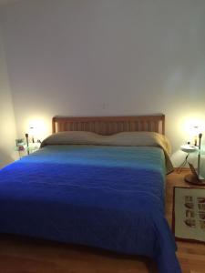 1 Schlafzimmer mit einem blauen Bett und 2 Tischen in der Unterkunft Apartment on Zdraviliski trg 7 in Rogaška Slatina
