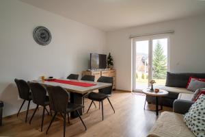 una sala de estar con una mesa, sillas y un sofá en Apartment Znaor, en Kupres