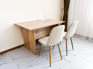 Bekarys Hotel في أستانا: طاولة خشبية مع كرسيين بجانب طاولة +16 صورة