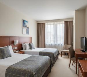 una camera d'albergo con due letti e una scrivania di Sabah Apart a Konya