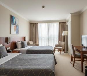 una camera d'albergo con due letti e una scrivania di Sabah Apart a Konya Altre 16 foto