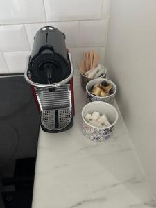 a toaster sitting on a counter with bowls of food at Les 3 anges in Houilles