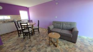 a living room with a couch and a table and chairs at 7 Rayos y el Sol in Río Gallegos
