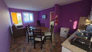 a kitchen with purple walls and a table and chairs at 7 Rayos y el Sol in Río Gallegos