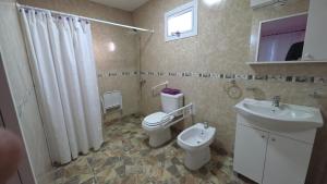a bathroom with a toilet and a sink at 7 Rayos y el Sol in Río Gallegos
