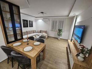 a living room with a table and chairs and a couch at Apartman IVA in Modriča