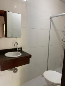 a bathroom with a sink and a toilet and a mirror at Pousada Recanto das Estrelas in Morro de São Paulo