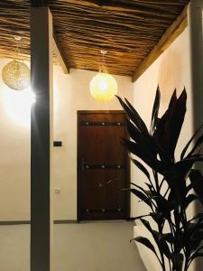 um corredor com duas luzes e uma porta de madeira em Tharurashmi Sea Pond Villa & Hostel, Dikwella em Dikwella