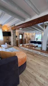 L'Ermitage of Meyriat في Brénod: غرفة معيشة كبيرة مع أريكة وطاولة