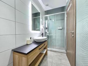 a bathroom with a sink and a shower at Ivi Central Apartments in Novi Sad
